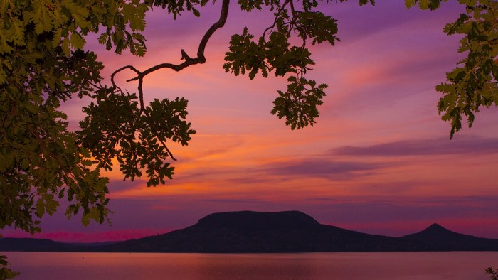 Sunset over a lake with a mountain and trees