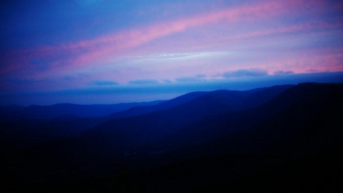 Mountain range at dusk with pink clouds
