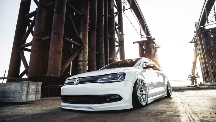 White Volkswagen Jetta parked near industrial structures