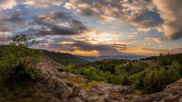 Sunset over a mountainous valley with clouds