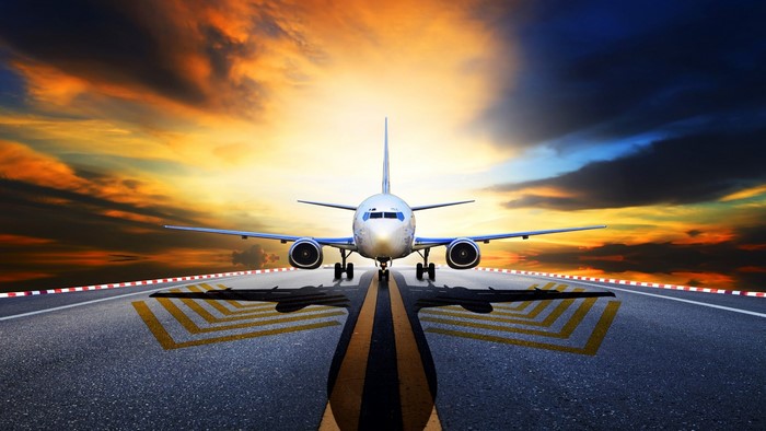 Airplane on runway at sunset