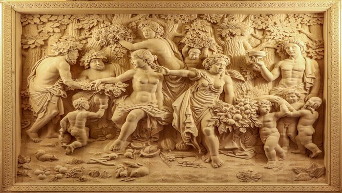Wood carving of a mythological scene with figures and cherubs