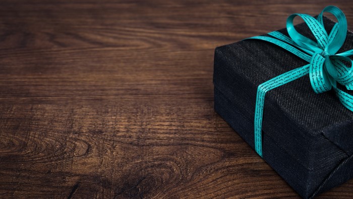 Gift box with ribbon on wooden table