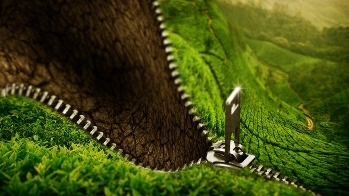 Zipper revealing green landscape from dry earth