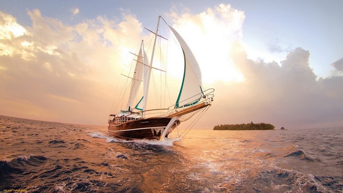 Sailboat sailing on the ocean at sunset