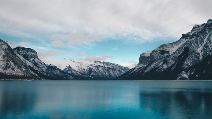 Snow-capped mountains reflecting in a blue lake
