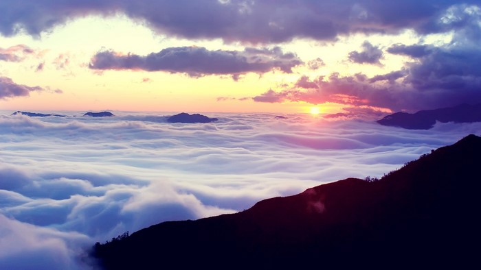 Sunrise over a sea of clouds with mountains