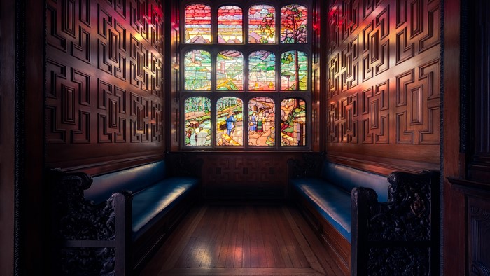 4K Stained glass window in a wood-paneled room