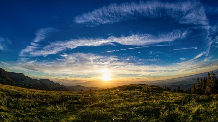 Sunrise over a grassy mountain landscape