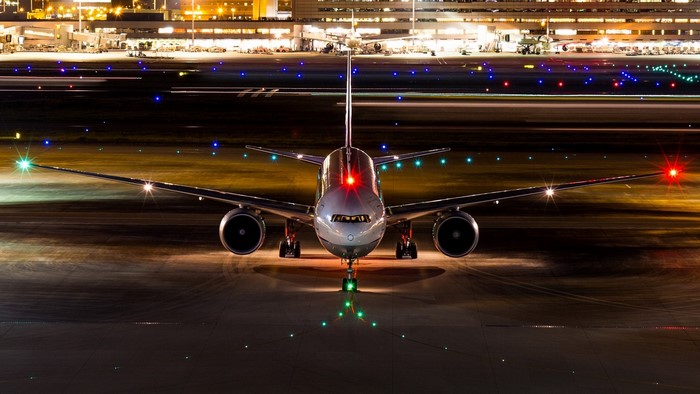 Boeing 777 300ER airplane on airport runway at night