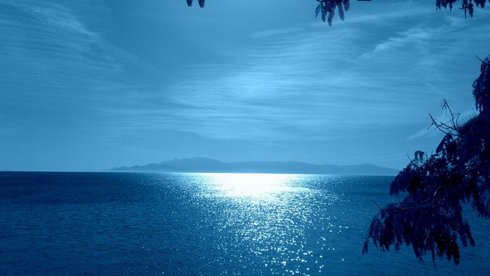 Sunlight on the Sea with Distant Mountains