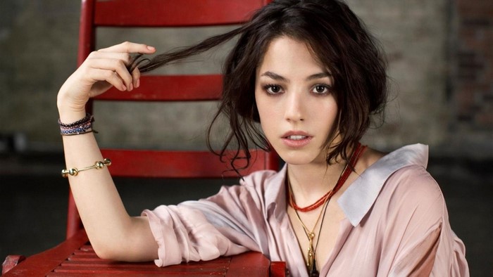 Olivia Thirlby sitting on a red chair