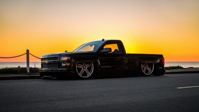 Black Chevrolet Silverado lowered truck at sunset