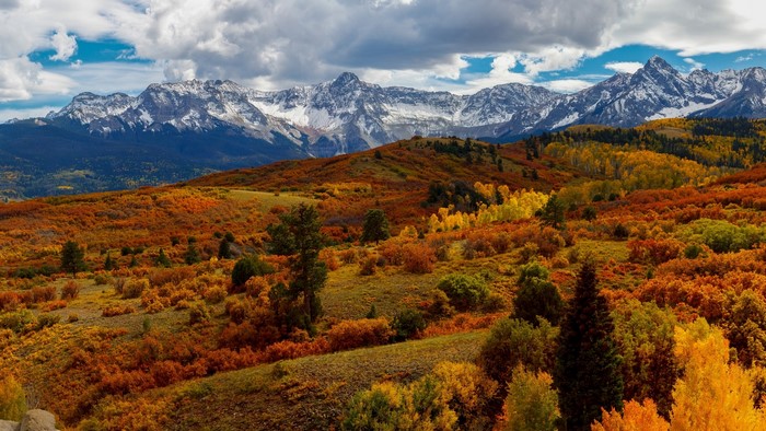 Autumn mountains with colorful foliage and snow-capped peaks