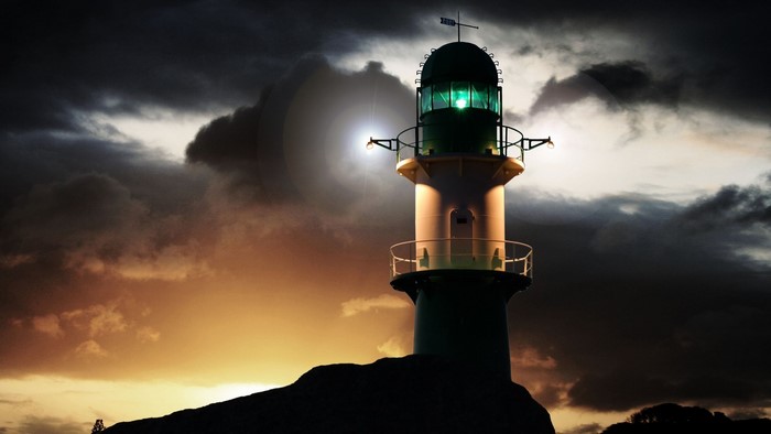 Lighthouse on a rocky outcrop at sunset