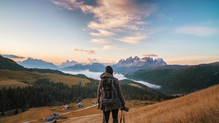 Woman with backpack and camera in mountains
