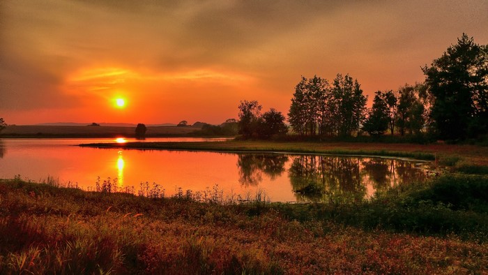 Sunset over a lake with trees