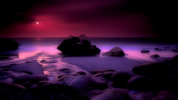 Purple sunset over rocky beach