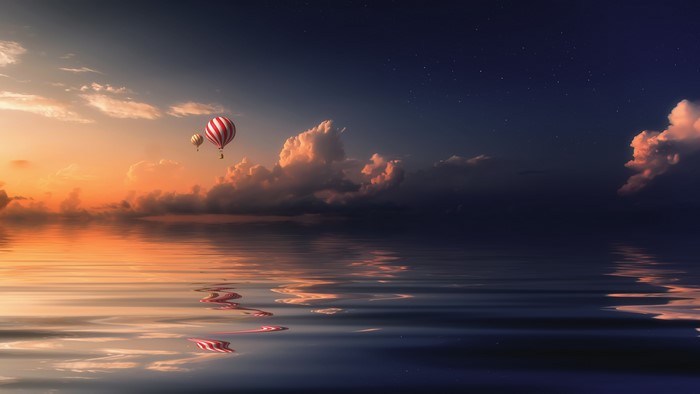 Hot air balloons over water at sunset
