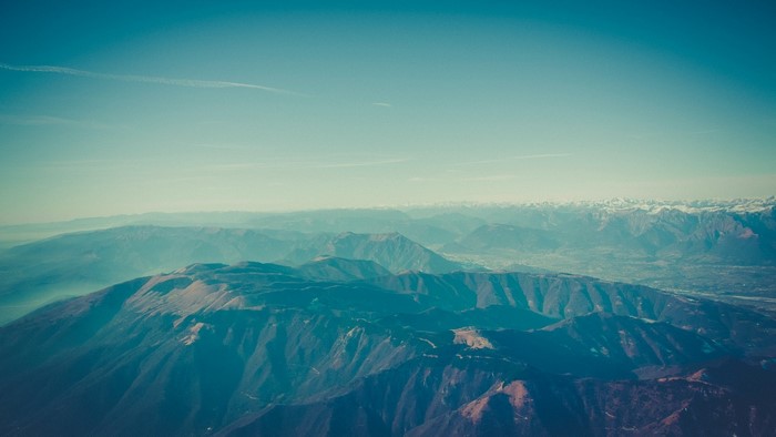 Aerial view of mountain ranges under a clear blue sky