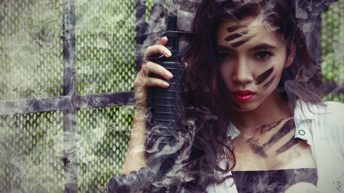 Girl with face paint holding a rifle