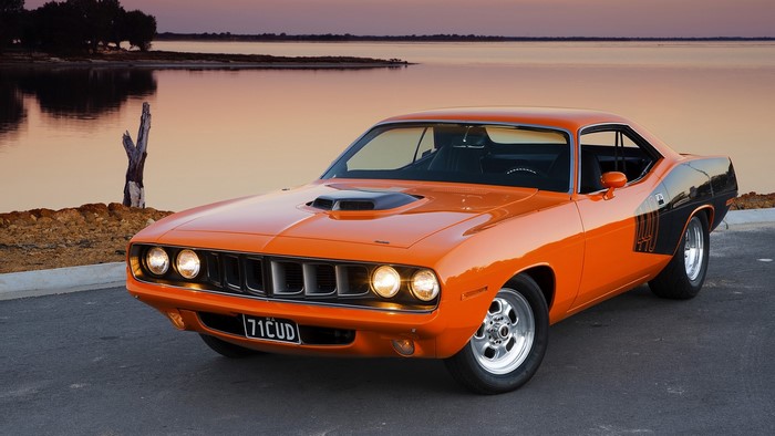 1971 Plymouth Barracuda parked by a lake at sunset