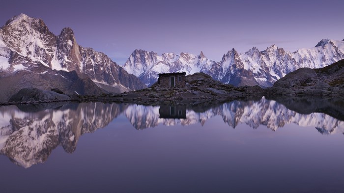 Mountain Range Reflected in Lake with Small Cabin