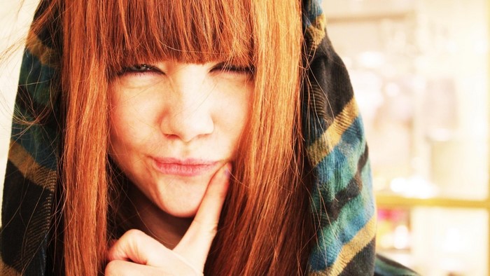 Young woman with red hair and a plaid scarf