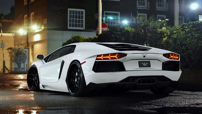 White Lamborghini Aventador parked on wet street at night