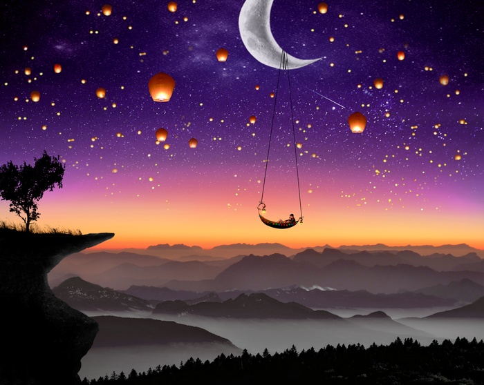 Person on swing under moon with lanterns