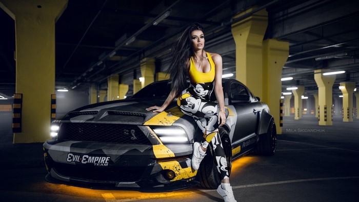 Woman in Mickey Mouse outfit posing with Ford Mustang
