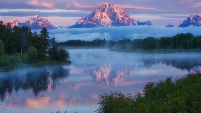 Mountains over a misty river at sunrise