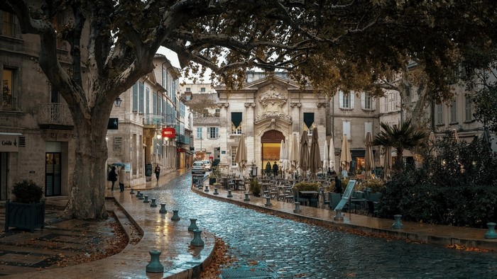 Cobblestone street with outdoor cafe seating and historic buildings