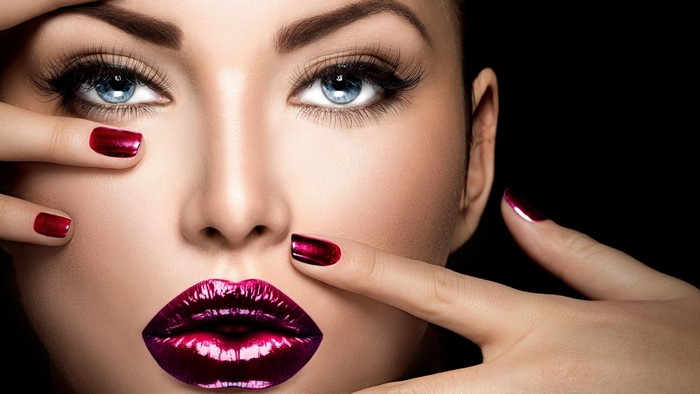 Woman with dramatic makeup and red nails