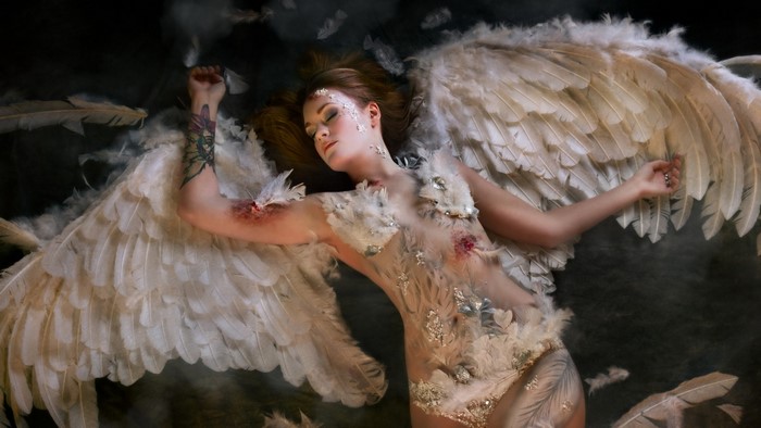 Fallen angel with white wings and wounds