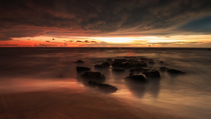 Sunset over the ocean with rocks
