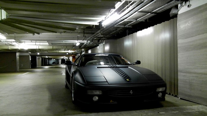 Matte black Ferrari in a parking garage