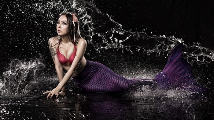 Mermaid with purple tail in water splashes