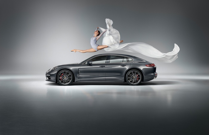 Ballerina performing a split jump over a Porsche Panamera Turbo