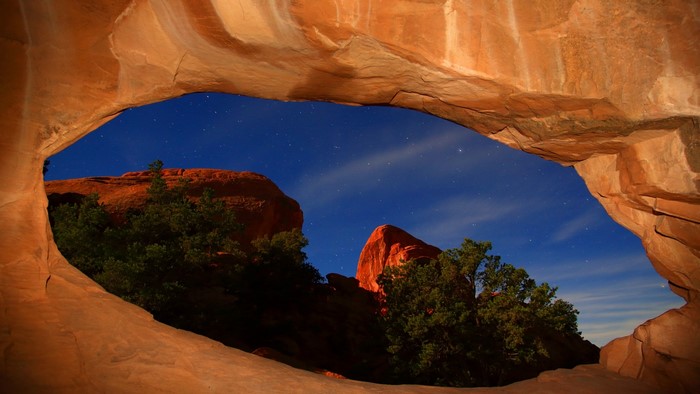 Night sky seen through a sandstone arch