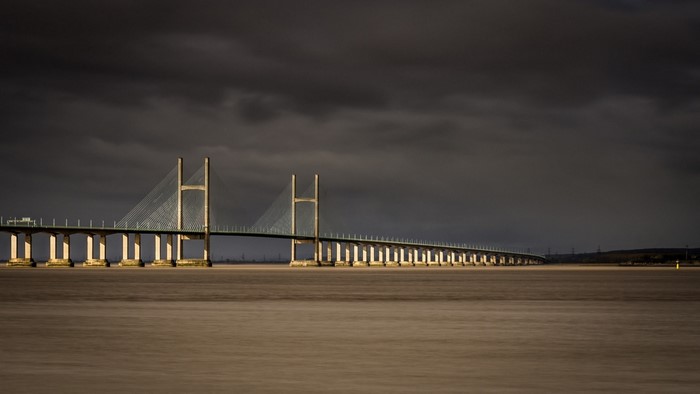Cable-stayed bridge over water under dark clouds