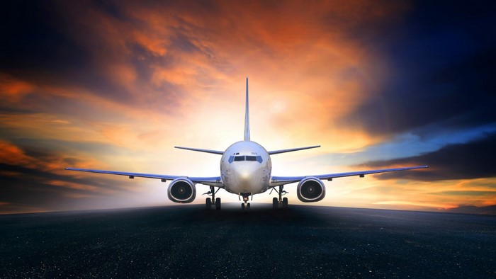 Airplane on runway at sunset