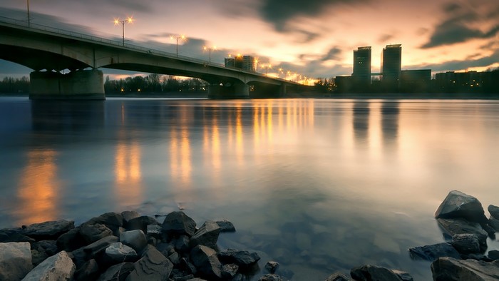 River bridge with city skyline at sunset