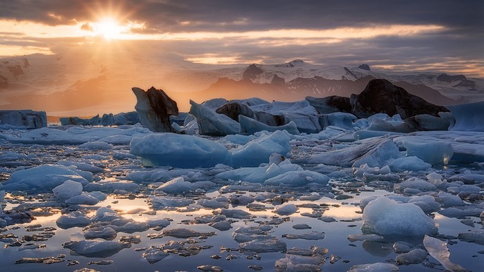 Icebergs floating in water at sunset