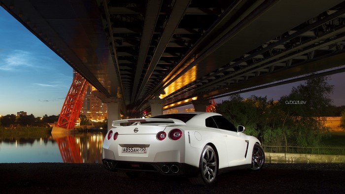 White Nissan GT-R under a bridge at night