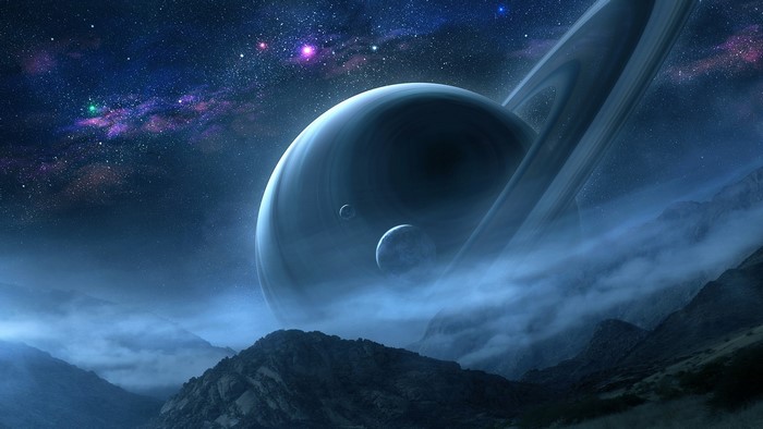 Saturn and moons over misty mountains