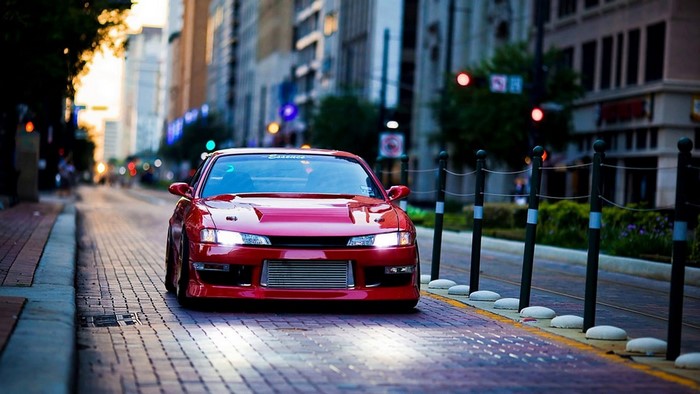 Red Nissan Silvia S14 parked on a city street