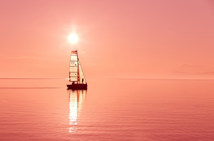 Sailboat on the ocean at sunset 4K
