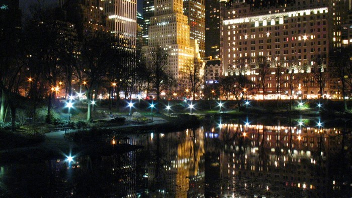 New York City skyline at night with reflections in water