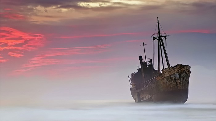Shipwreck at sunset with colorful clouds